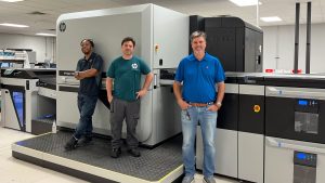 Ironmark employees standing in front of printing equipment