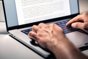 A closeup of hands typing on a keyboard