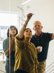 A group of people writing on a whiteboard