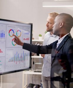 Two people looking at analytics data on a screen