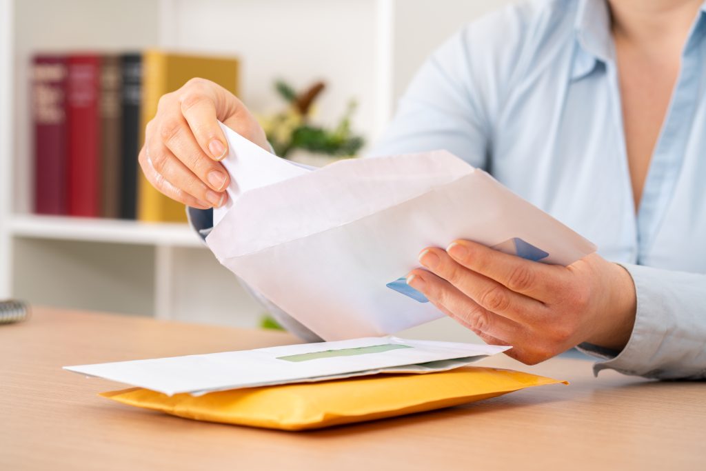 A person removing papers from an envelope