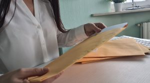 A woman removing papers from an envelope