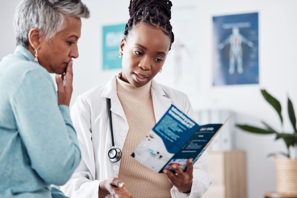 A doctor looking at a pamphlet with her patient